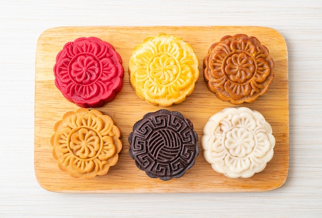 kolorowe chińskie ciasto księżycowe o mieszanym smaku na drewnianym talerzu