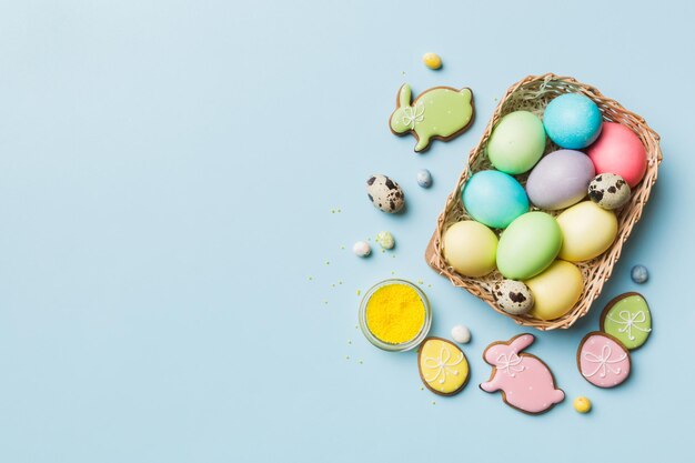 Kolorowe ciasteczka wielkanocne w koszu z wieloma kolorami Pisanki na kolorowym tle Pastelowy kolor Koncepcja wakacji wielkanocnych jaj z miejsca na kopię