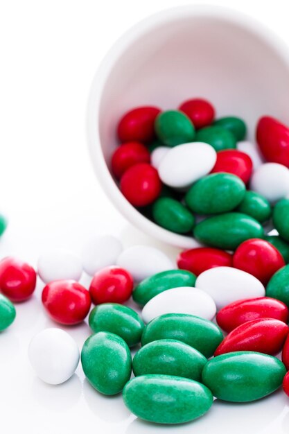 Kolorowe cukierki czerwone, zielone i białe na białym tle.