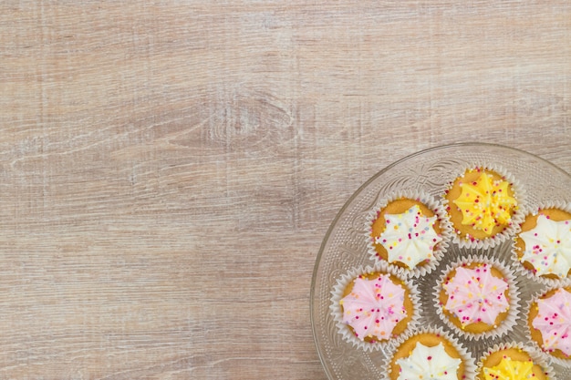 Kolorowe cupcakes na białym tle drewna. Widok z góry z miejscem na tekst.