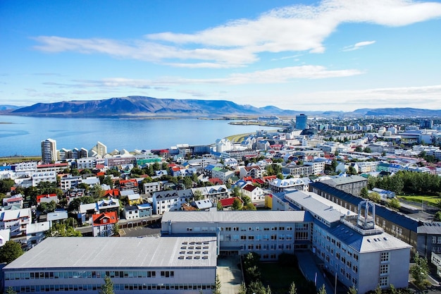 Kolorowe dachy domów w Rekjaviku na tle błękitnego nieba i dużej góry Islandii