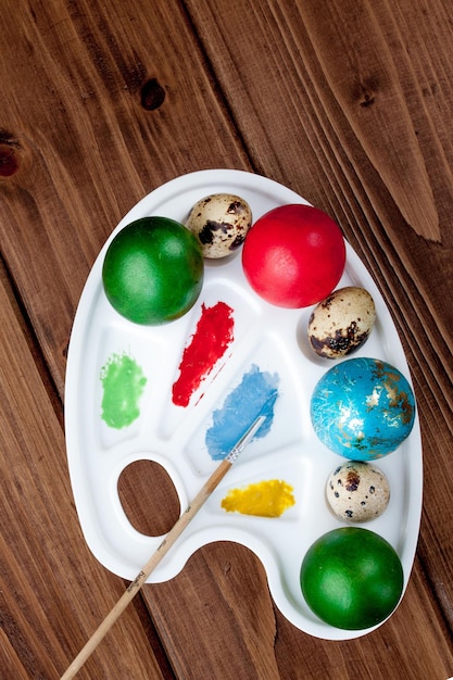 Kolorowe jajka i farby na drewnianym stole Wielkanocne tło