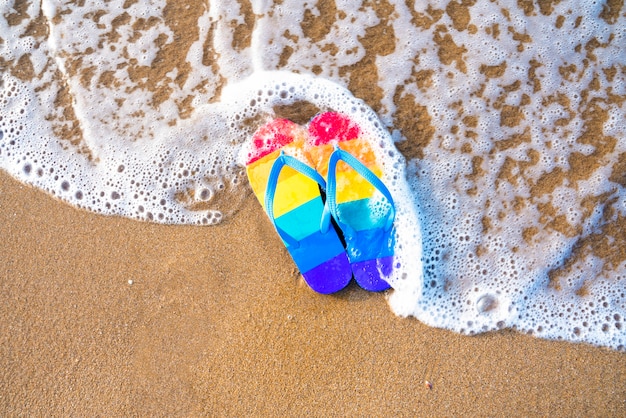 Zdjęcie kolorowe kapcie na plaży w letni dzień - flaga dumy gejowskiej - klapki