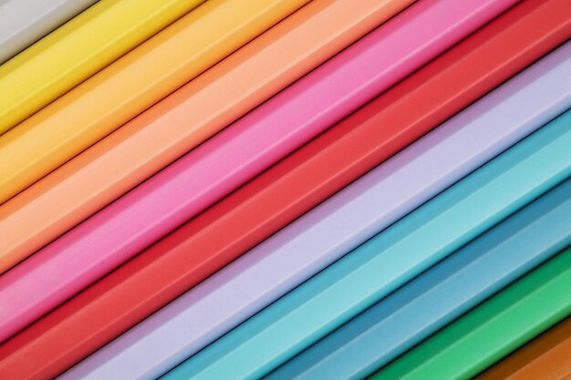 Kolorowe kredki w pastelowych kolorach na różowym tle Abstrakcyjna tła ołówek