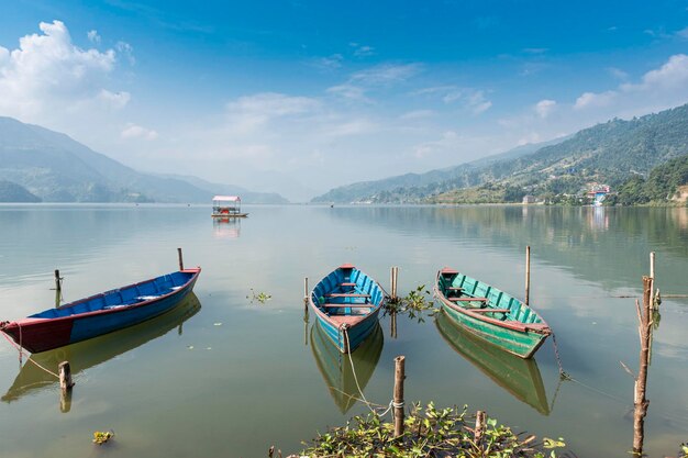 Kolorowe łódki na brzegu pięknego jeziora Phewa Pokhara Nepal z pasmem Annapurna w tle