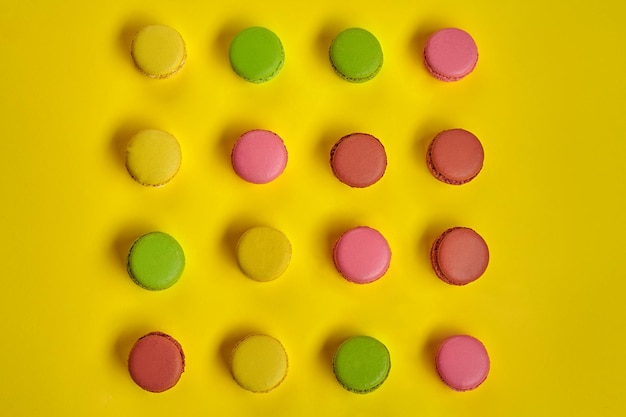 Kolorowe macaron lub macaroon słodkie słodycze na bazie bezy na żółtym tle Przestrzeń kopiowania przeznaczone do walki radioelektronicznej
