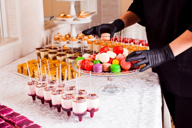 Kolorowe makaroniki i inne desery serwowane na stole Serwis cateringowy