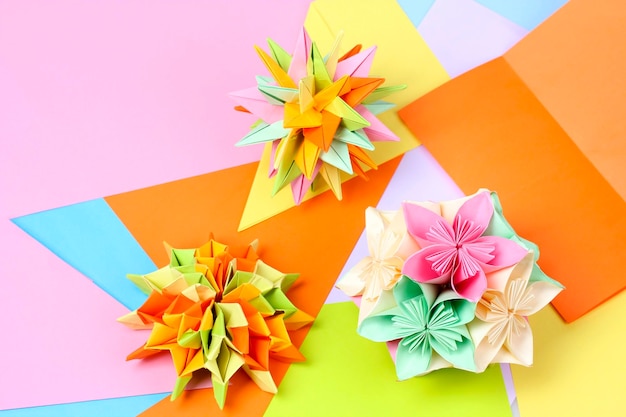 Kolorowe origami kusudamas na jasnym tle papieru