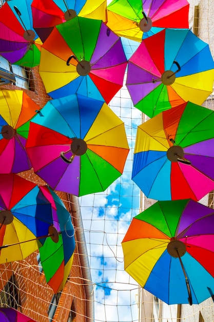 Kolorowe parasole wiszące nad ulicą z błękitnym niebem