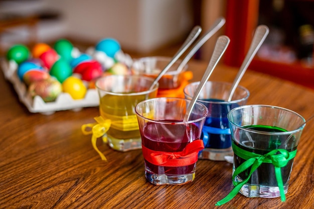 Kolorowe pisanki w szklanych filiżankach na stole