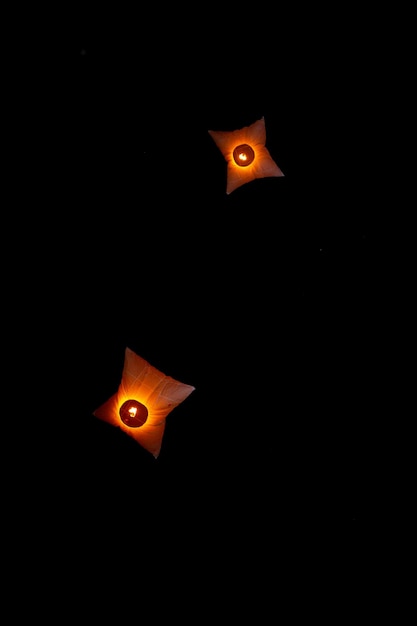 Kolorowe prostokątne papierowe latarnie pływające lecą na ciemne nocne niebo podczas festiwalu Probarona Purnima