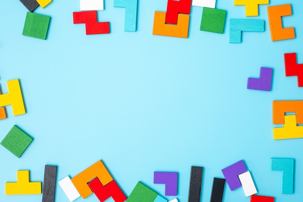 Kolorowe puzzle drewna na niebieskim tle, blok geometryczny kształt z miejsca na kopię. Koncepcje logicznego myślenia, Zagadka, rozwiązania, racjonalność, strategia, Światowy Dzień Logiki i Edukacja