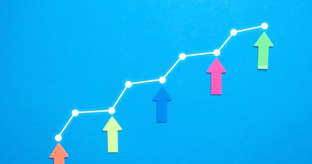 Zdjęcie kolorowe strzałki i wykres wzrostu na niebieskim tle