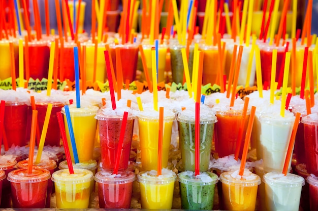 Kolorowe szklanki soku ze świeżych owoców ze słomy