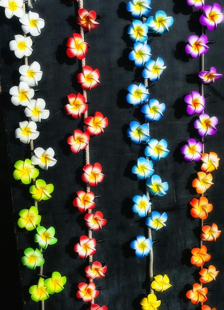 Zdjęcie kolorowe sztuczne kwiaty dekoracyjne wiszące na czarnej tkaninie