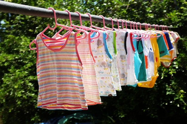 Zdjęcie kolorowe ubrania dla niemowląt na wieszaku suszą się na słońcu