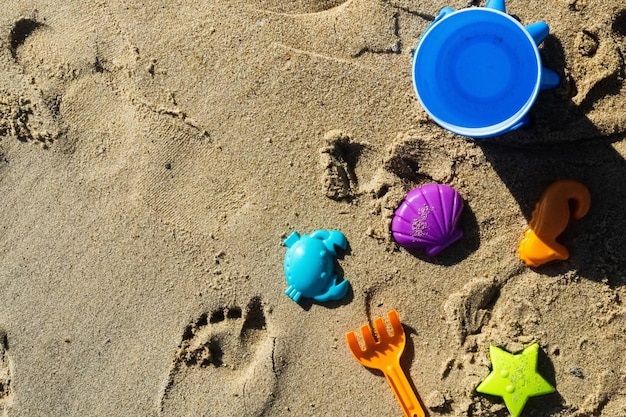 Kolorowe zabawki dla dzieci do zabawy w piasku na plaży lub basenie Dziecięce wiadro z łopatą i foremki do piaskownicy pod morzem Słoneczny dzień