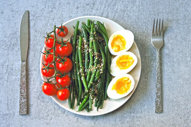 Kolorowe, zdrowe jedzenie. flatlay. Miska Buddy z jajkami, zieloną fasolą i pomidorami cherry.