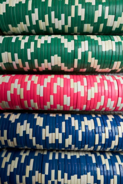 Kolorowe żetony do gry w pokera leżą na stole do gry w stosie Kolorowe żetony do kasyna