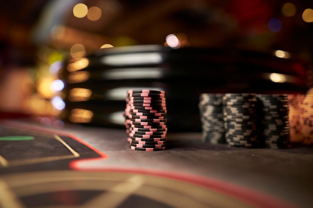 Kolorowe żetony do gry w pokera leżą na stole do gry w stosie. Tło dla kasyna online.