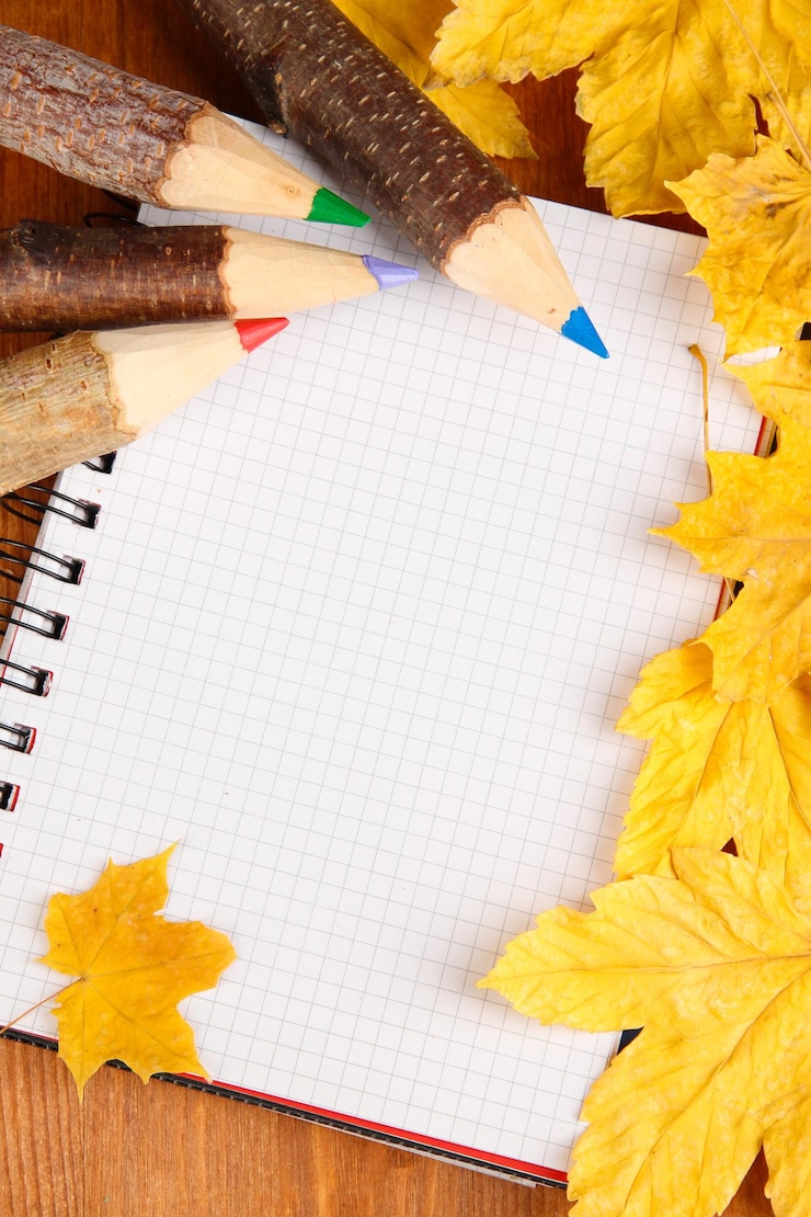 Zdjęcie kolorowi drewniani ołówki z jesienią leafs na drewnianym stole