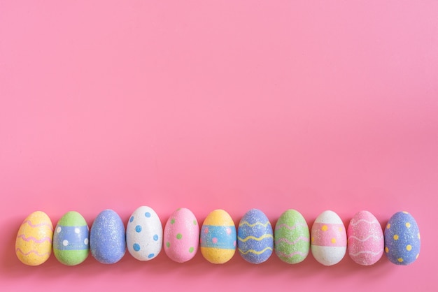 Kolorowi Easter jajka na różowym pastelowego koloru tle z przestrzenią.