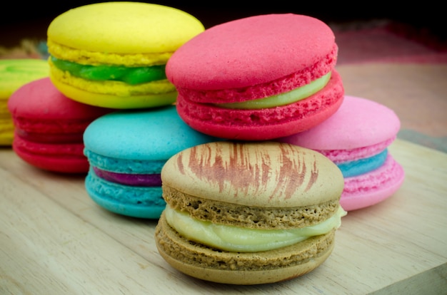 Kolorowi macarons na drewnianym tle