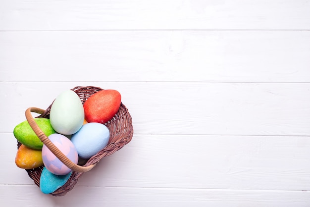 Kolorowi malujący Easter jajka w brown koszu