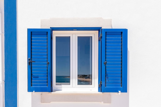 Zdjęcie kolorowy biały dom z niebieskimi okiennicami w algarve w portugalii