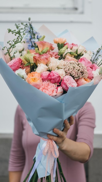 Kolorowy bukiet różnych świeżych kwiatów w rękach kwiaciarni Rustykalne tło kwiatowe