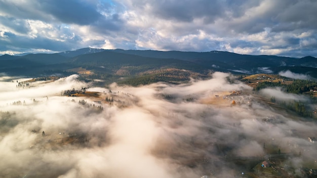 Kolorowy Jesienny Poranek Nad Mglistą Górską Doliną. Wioska Pokryta Niskimi Chmurami. Spadek Krajobrazu Wiejskiego. Mglisty, Zimny Listopadowy Poranek. Karpaty, Ukraina, Europa.