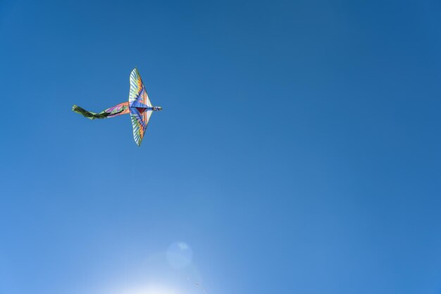 Kolorowy latawiec szybuje wysoko na niebie Błękitne niebo Sportowy festiwal latawców Czysty poniedziałek w Grecji Latający latawiec z wijącym się ogonem Copyspace