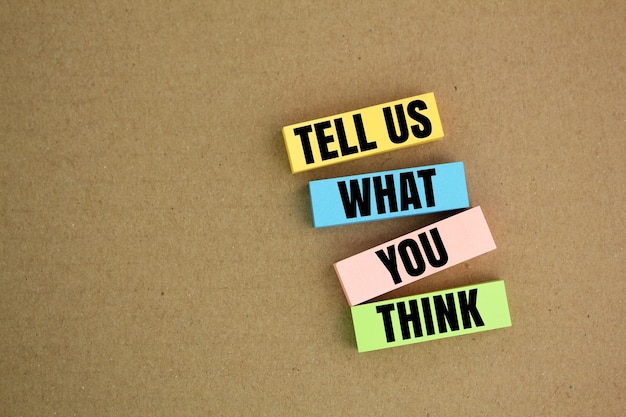 Zdjęcie kolorowy papier z napisem powiedz nam, co myślisz, pomysł koncepcyjny lub innowacja
