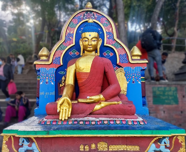 Kolorowy posąg Buddy siedzi w parku.