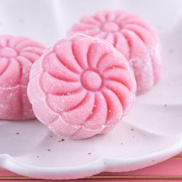 Kolorowy śnieg skóry księżyc ciasto słodki śnieżny mooncake tradycyjny pikantny deser na MidAutumn Festival na pastelowym blado różowym tle z bliska styl życia