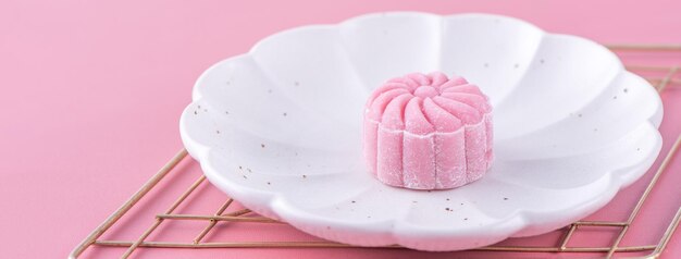 Kolorowy śnieg skóry księżyc ciasto słodki śnieżny mooncake tradycyjny pikantny deser na MidAutumn Festival na pastelowym blado różowym tle z bliska styl życia