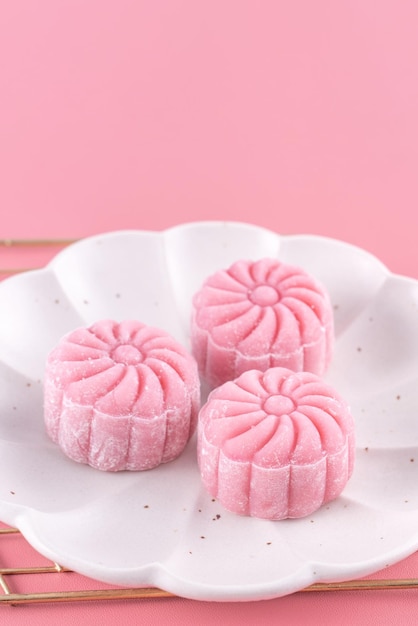 Kolorowy śnieg skóry księżyc ciasto słodki śnieżny mooncake tradycyjny pikantny deser na MidAutumn Festival na pastelowym blado różowym tle z bliska styl życia