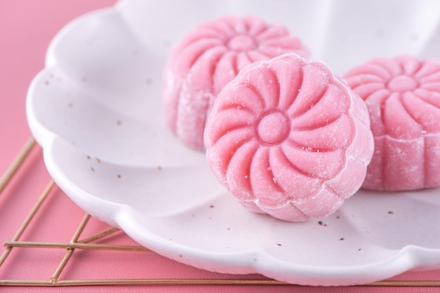 Kolorowy śnieg skóry księżyc ciasto słodki śnieżny mooncake tradycyjny pikantny deser na MidAutumn Festival na pastelowym blado różowym tle z bliska styl życia