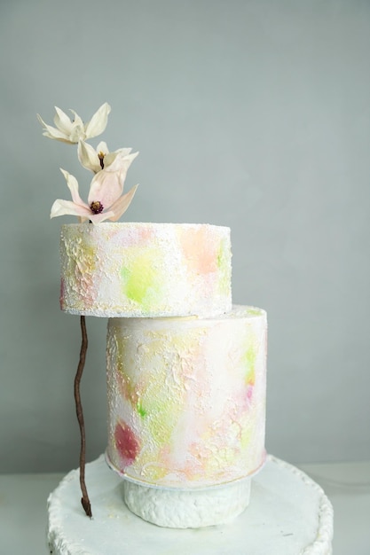 Kolorowy tort ślubny z kwiatami z papieru waferowego z jasnymi kolorami na stojaku