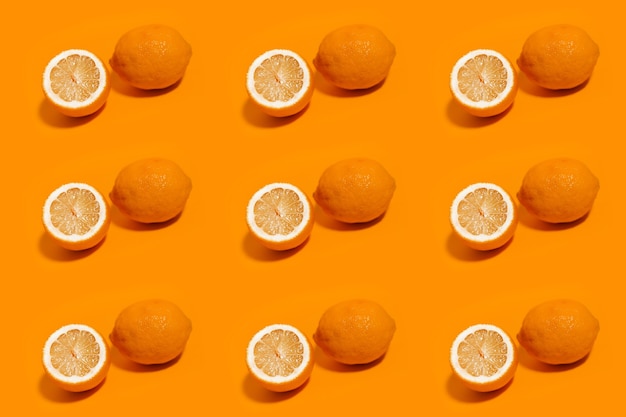 Kolorowy wzór cytryn na białym tle na tle koloru pomarańczowego.