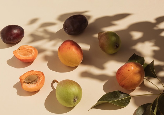 Kolorowy wzór jedzenia wykonany z gruszki śliwki morelowej i liści Światło słoneczne i cień drzewa Płaskie lay