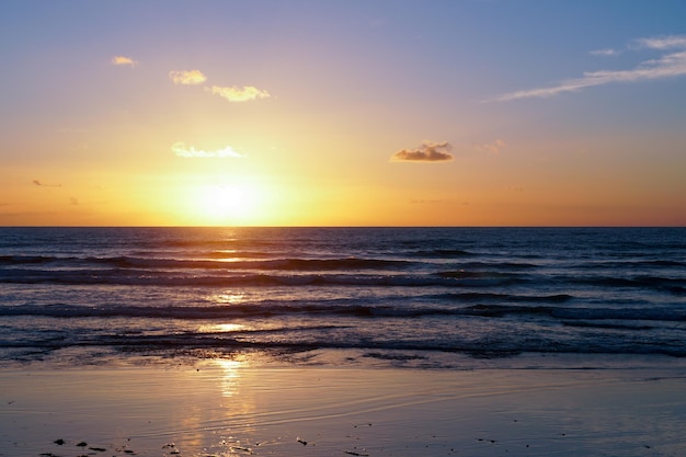 Kolorowy zachód słońca na plaży nad oceanem z głębokim zachmurzonym niebem Piękna chmura nad morzem podczas zachodu słońca