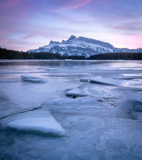 kolorowy zachód słońca na zamarzniętym jeziorze z górą, zachód słońca nad dwoma jack lake, banff, alberta, kanada