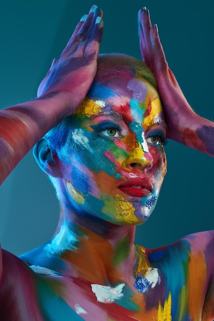Kolory, które widzimy i których używamy, to nic innego jak magiczne ujęcie studyjne przedstawiające młodą kobietę pozującą z różnokolorową farbą na twarzy
