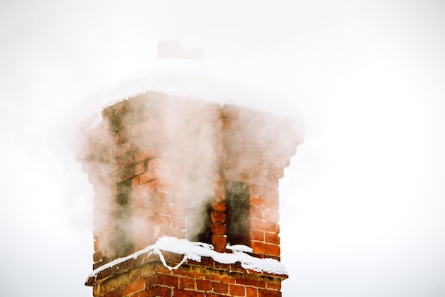 Zdjęcie komin na dachu domu zimą w śniegu