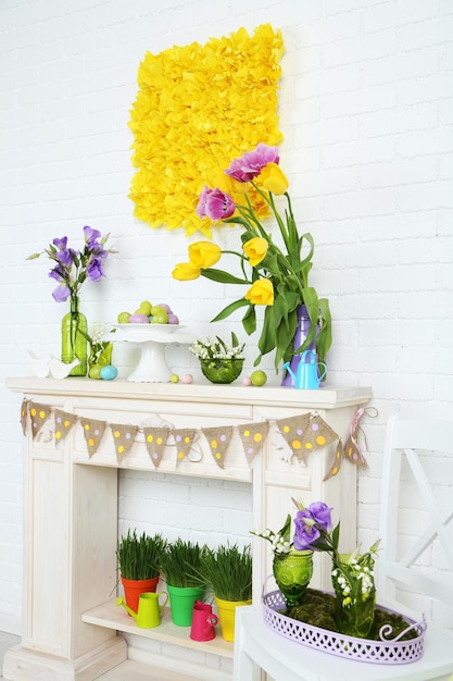 Zdjęcie kominek z pięknymi wiosennymi dekoracjami w pokoju