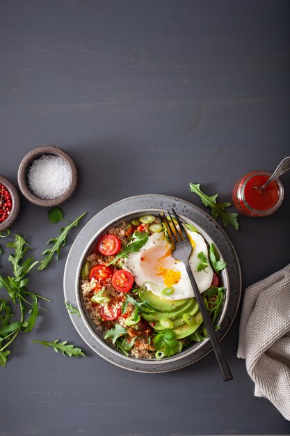 Komora ryżowa z jajkiem sadzonym, awokado, pomidorem, rukolą. Zdrowy wegetariański lunch