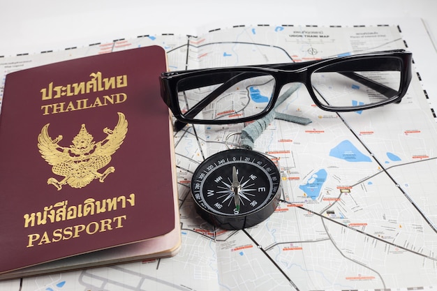 Kompas, paszport, okulary na mapie dla turystów