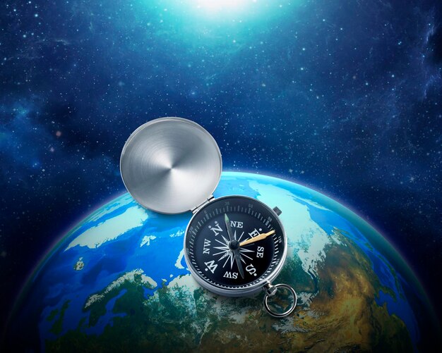 Zdjęcie kompas umieszczony na niebieskiej ziemi w przestrzeni kosmicznej kolorowy układ słoneczny destinacja podróży i koncepcja nawigacji na całym świecie