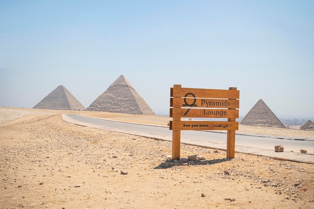 Zdjęcie kompleks archeologiczny wielkich piramid egipskich znajduje się na płaskowyżu giza na pustyni libijskiej na lewym brzegu znaku nilu na drodze przed piramidami